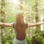 femme qui écarte ses bras dans la foret